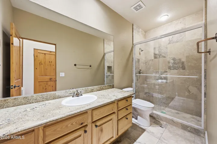 Guest bath featuring beautiful natural stone and wood