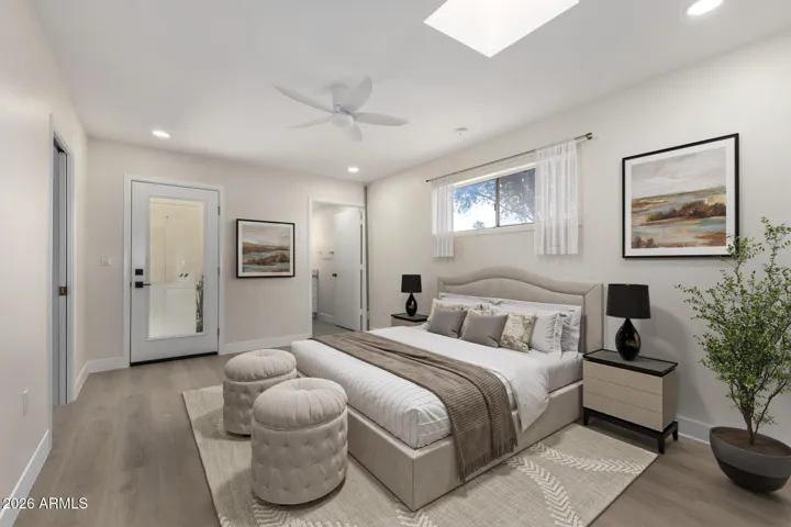 Spacious bedroom with recessed lighting and a skylight