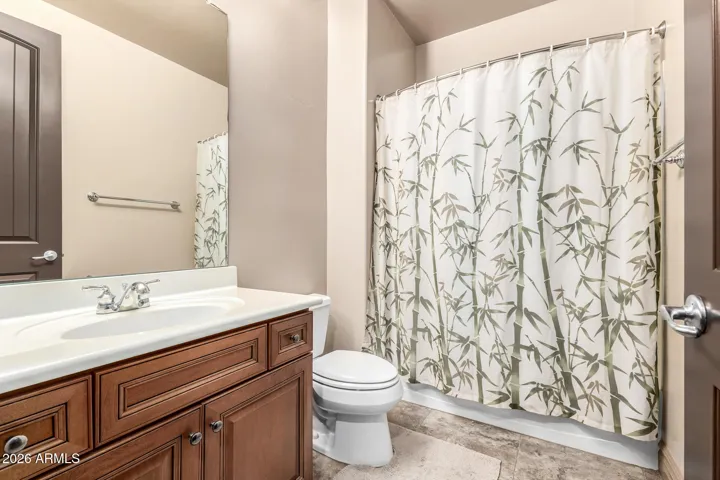 Clean and functional bathroom featuring single-sink vanity, ample cabinet storage, and tub/shower combo. Located in Goodyear, this space offers practicality with updated fixtures and neutral finishes.