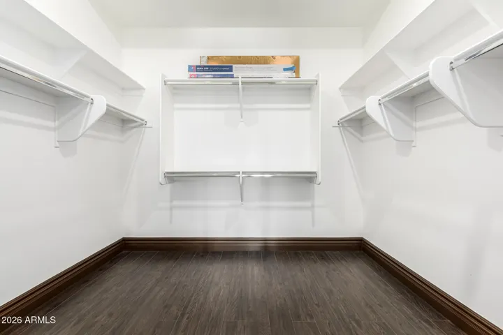 Large walk-in closet in this Goodyear home featuring built-in shelving and hanging space, ideal for organized storage and maximizing functionality.