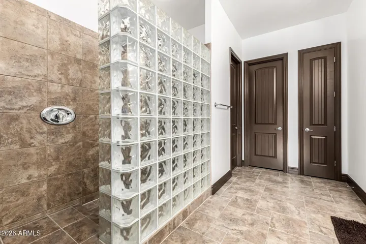 Stylish walk-in shower with glass block detail in this Goodyear home, complemented by tile surrounds and modern fixtures, offering a spa-like bathroom experience.