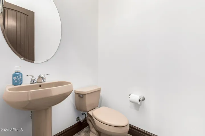 Well-maintained powder room with pedestal sink and clean finishes. A practical feature in this Goodyear home, ideal for guests and everyday convenience.