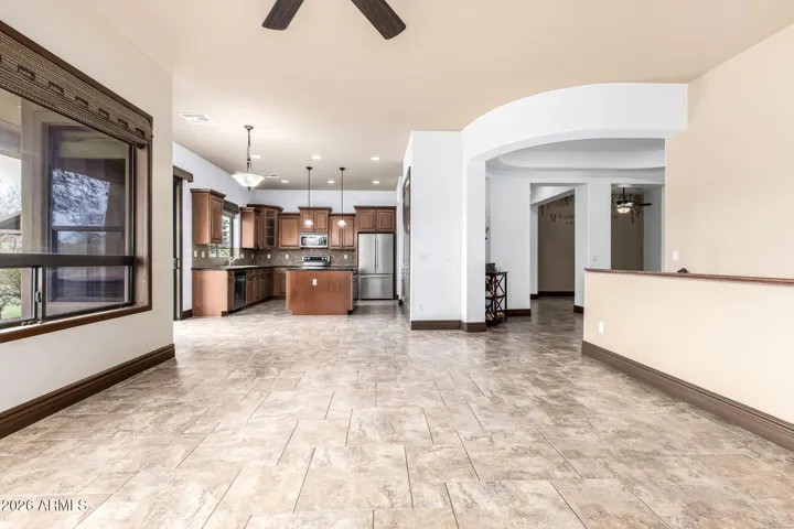 Wide open layout connecting the gourmet kitchen to the main living area. Ideal for entertaining, this Goodyear home features tile flooring, recessed lighting, and a spacious design.