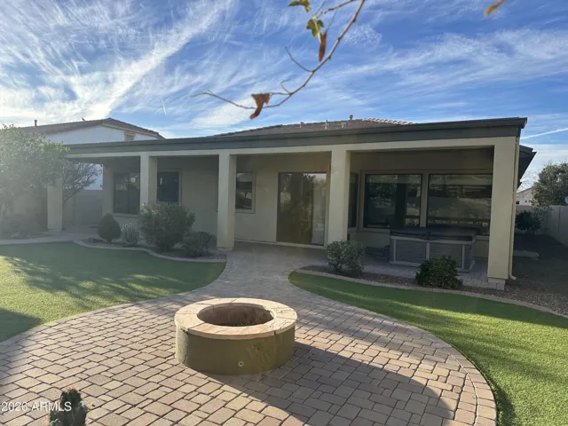 Expansive covered patio in Goodyear with paver flooring and lush yard views. Designed for entertaining, with ample space for outdoor seating and relaxing evenings.