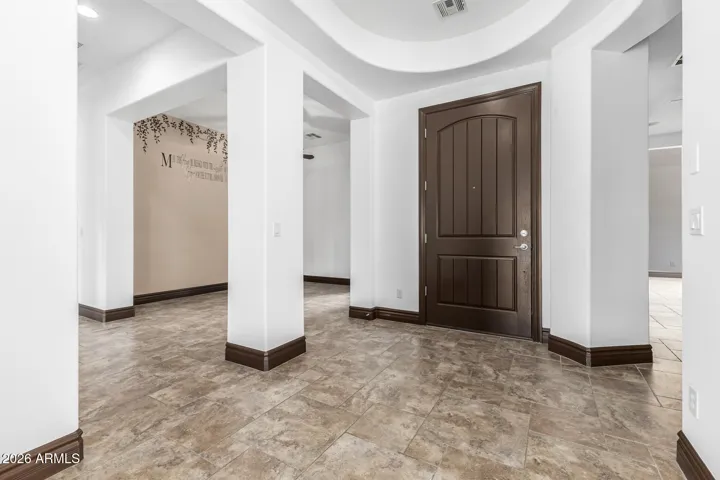 Spacious entry with tile flooring, custom baseboards, and open layout. This welcoming interior space highlights upgraded finishes and sets the tone for the rest of this beautifully maintained Goodyear home.