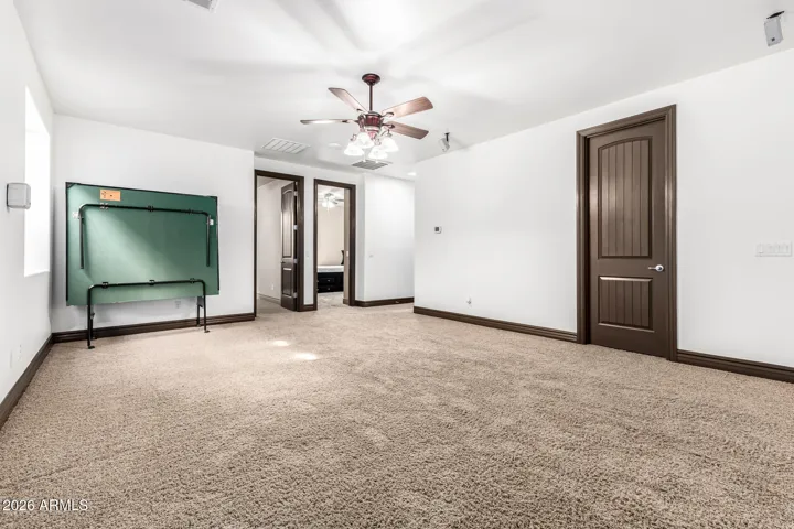 Expansive bonus room in Goodyear featuring soft carpet, multiple ceiling fans, and flexible layout. Perfect for a game room, media space, or home gym with plenty of room to customize.