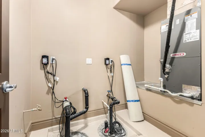 Functional utility space in Goodyear with organized plumbing, water softener system, and mechanical access. Ideal for maintaining energy efficiency and home systems with easy accessibility.