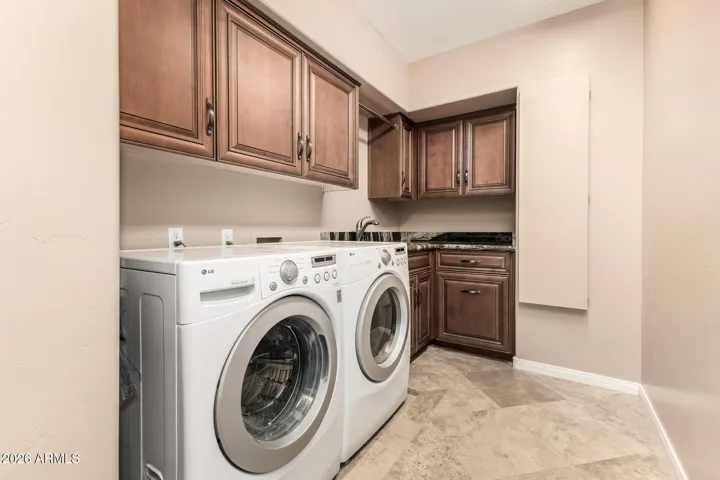Laundry room with sink, full cabinetry and built in ironing board