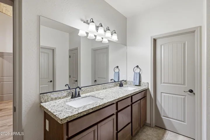 Dual vanity on executive height vanity topped with granite countertops