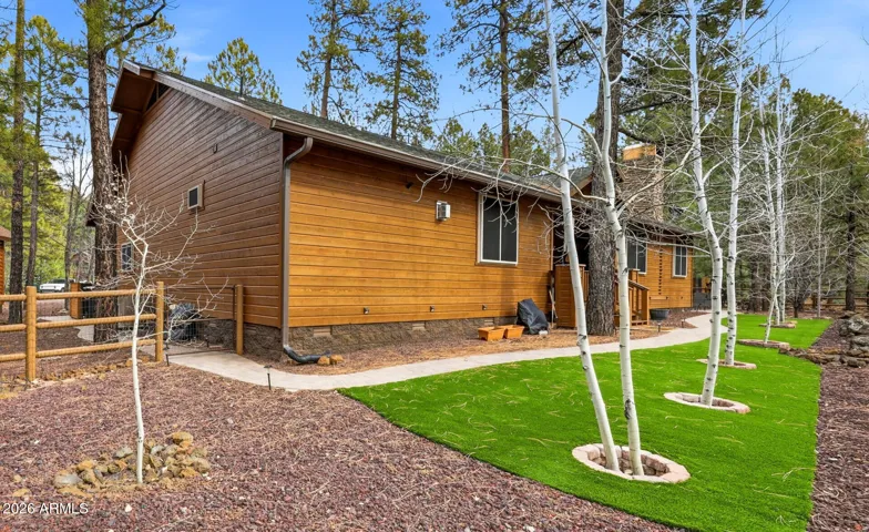 Artificial grass area in back with landscaping and sprinkler system in back and front