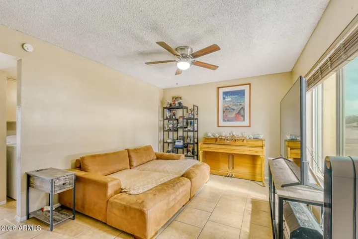 Bright living room with tile floors and ceiling fan