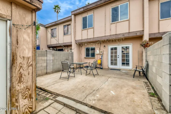Private patio with block wall fencing and attached storage shed for outdoor gear.