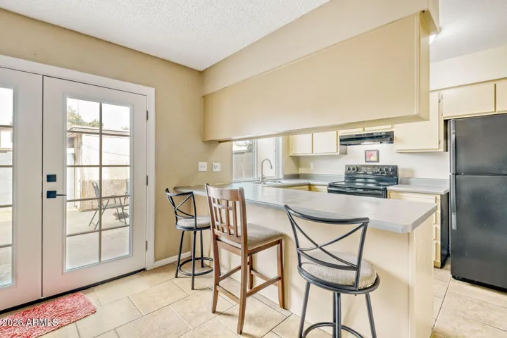 Eat in kitchen bar with seating, natural light, and direct access to the patio.