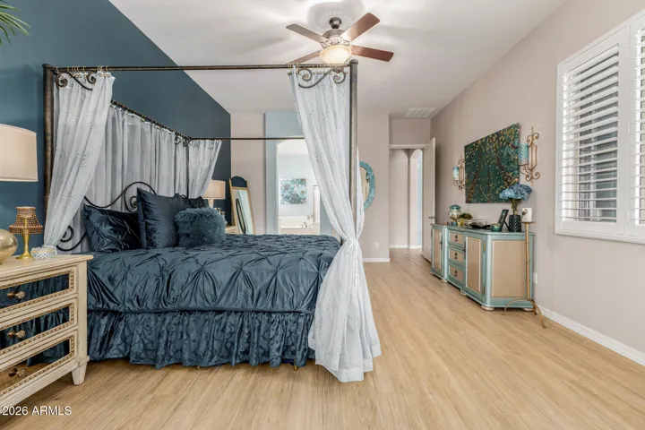 Primary bedroom with accent wall and luxury vinyl flooring.