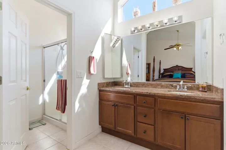 Well-appointed primary bath with dual sinks and ample storage + large walk-in closet.
