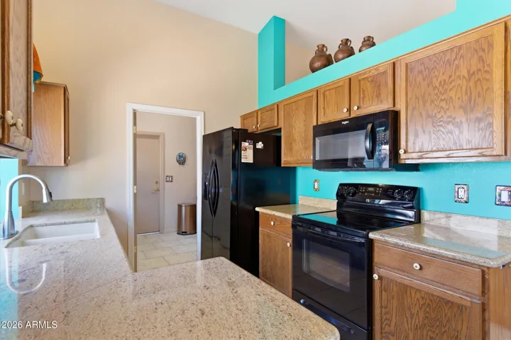 Kitchen featuring black appliances and generous cabinetry.