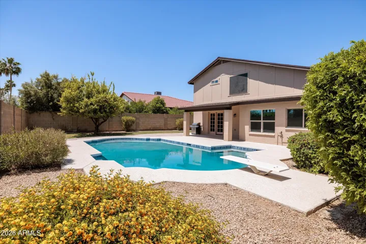 Enjoy an oversized diving pool in this private backyard.