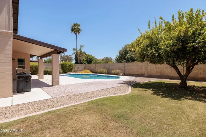 The backyard includes a grassy play area and mature lemon tree.