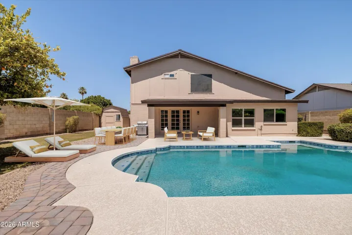 Peaceful backyard with refreshing dive pool, grassy play areas, and extra decking for outdoor living.