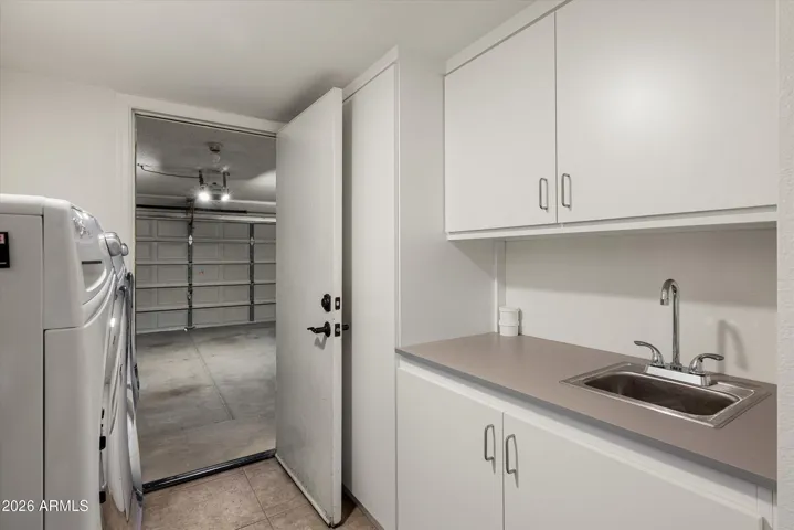 The laundry has been upgraded with new upper and lower cabinetry, as well as a sink. The white whirlpool duet washer/dryer convey with the sale.