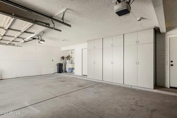 Built-in cabinetry, utility sink, and storage closet.