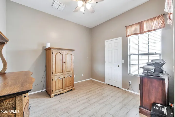 Inviting living room with large windows, tile flooring, and plenty of natural light. This flexible space offers comfort and versatility, ideal for relaxing or hosting guests.