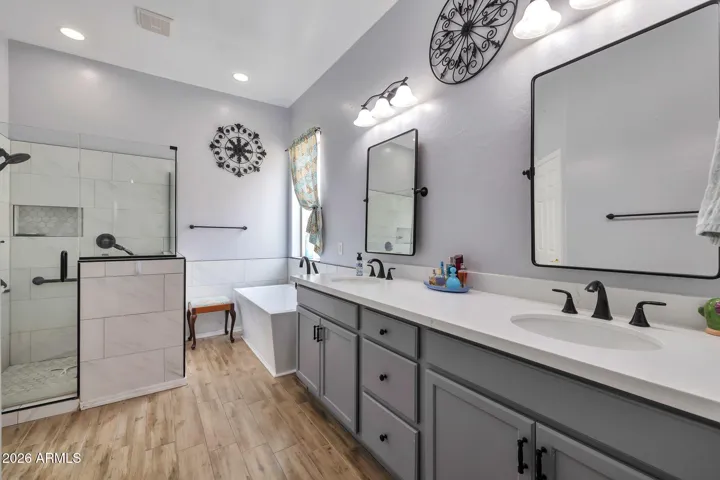 Updated primary bathroom with dual sinks, modern fixtures, and a large vanity. Features include a walk-in glass shower, soaking tub, and stylish finishes, creating a spa-like retreat within this Glendale home.