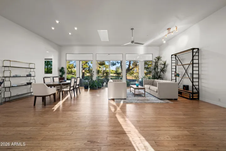 Expansive Scottsdale great room with large windows, wood flooring, and seamless indoor-outdoor flow. Perfect for entertaining with abundant natural light and scenic views.