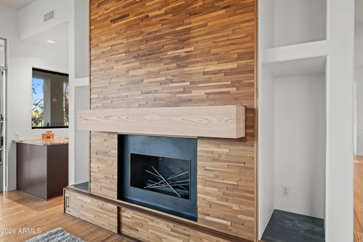 Stunning Scottsdale fireplace with custom walnut accent wall and modern design. A warm focal point that adds style and comfort to the living space.