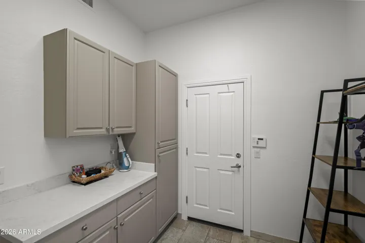Scottsdale home includes a practical drop zone with built-in storage, cabinetry, and counter space. Ideal for organizing daily essentials and household items.