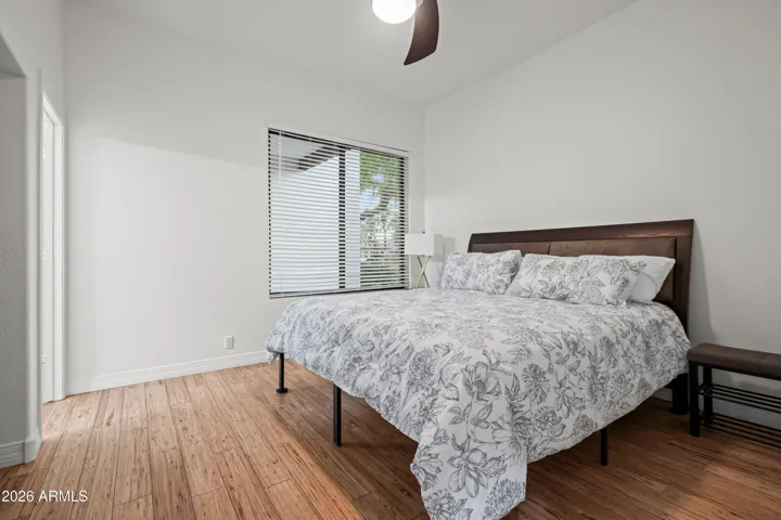 Scottsdale bedroom designed to accommodate a king-size bed, featuring wood flooring, natural light, and a comfortable layout for everyday living.