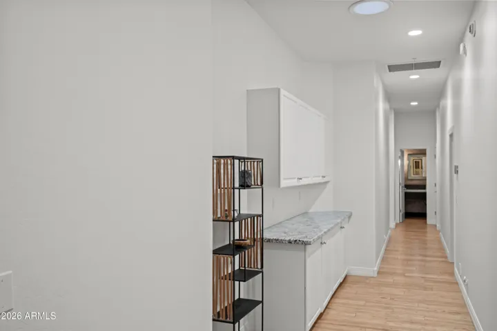 Scottsdale bedroom hallway featuring built-in linen storage and cabinetry. Clean design offers added convenience and efficient organization.