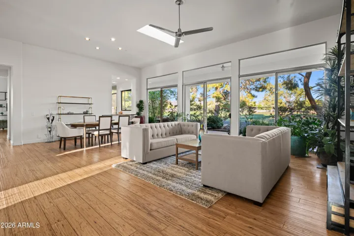 Spacious Scottsdale great room featuring modern design, wood flooring, and open-concept living. Large windows connect indoor spaces to the outdoor landscape.
