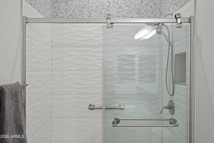 Scottsdale bathroom showcasing a sleek walk-in glass shower with modern tile, built-in niche, and updated fixtures. Designed for both style and easy maintenance.