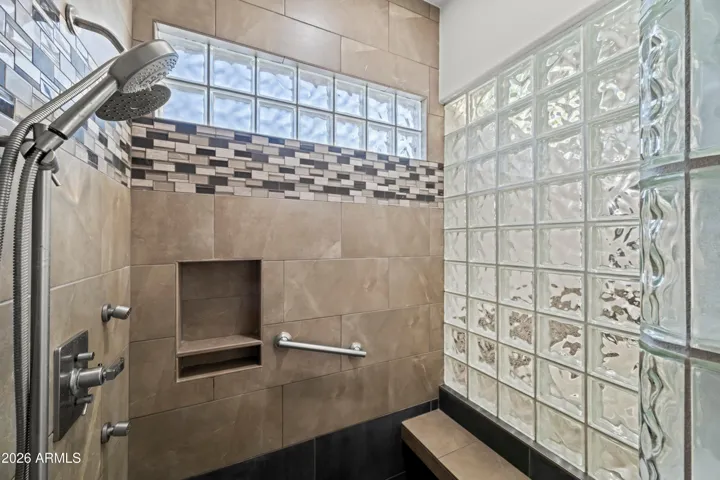 Spacious Scottsdale walk-in shower with tile surround, glass block wall, and modern fixtures. Designed for accessibility and contemporary style.