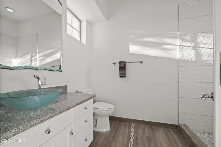 Scottsdale bathroom featuring an ensuite layout with walk-in shower, modern tile finishes, and updated vanity. Designed for comfort and convenience.