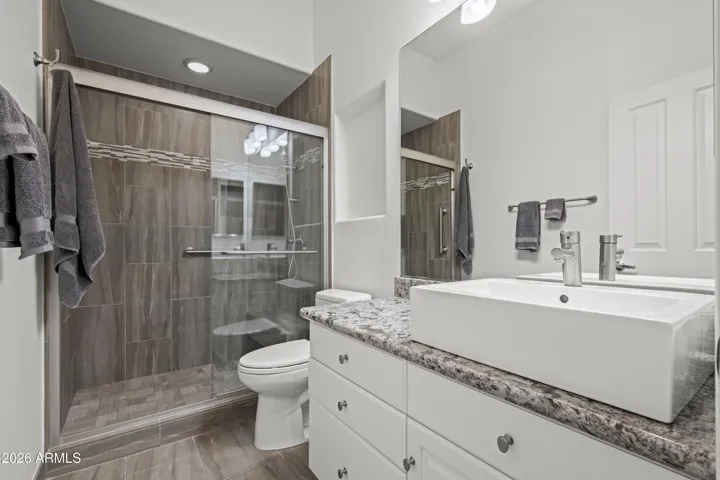 Scottsdale ensuite bathroom featuring updated vanity, vessel sink, and granite countertops. Walk-in shower adds modern functionality.
