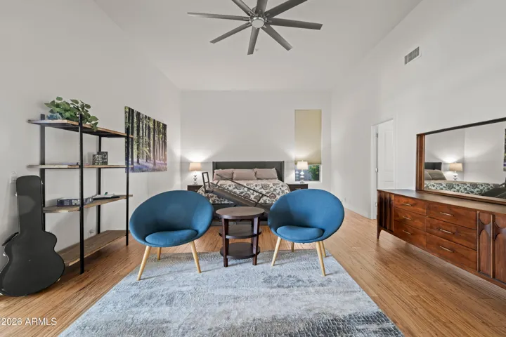 Spacious Scottsdale primary suite featuring a dedicated sitting area, wood flooring, and modern finishes. Bright layout offers comfort, flexibility, and a relaxing retreat.