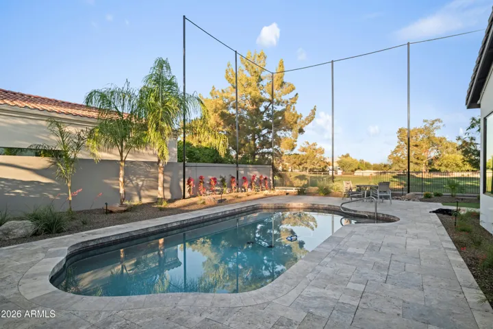 Scottsdale backyard showcasing a saltwater pool with surrounding stone patio and landscaped yard. Ideal for energy-efficient outdoor living and entertaining.