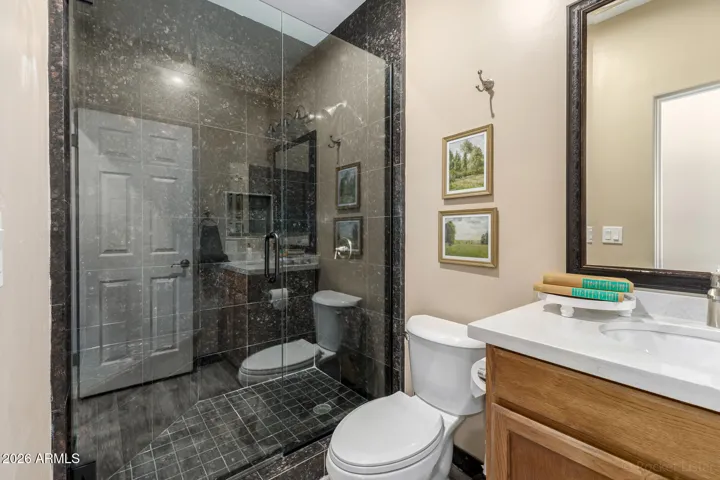 Full Modern bathroom downstairs with glass-enclosed shower and sleek finishes.