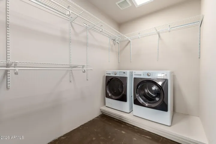 Convenient in-unit laundry space with shelving for added storage.