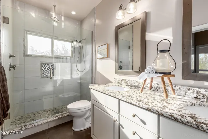 Bright bathroom featuring a glass-enclosed shower and modern finishes.