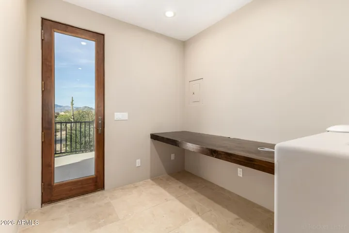 Multi-purpose space with built-in desk and direct access to the outdoor balcony.