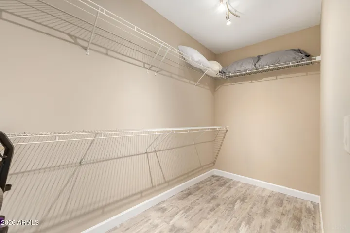 Spacious primary closet with built-in shelving and plenty of storage options.
