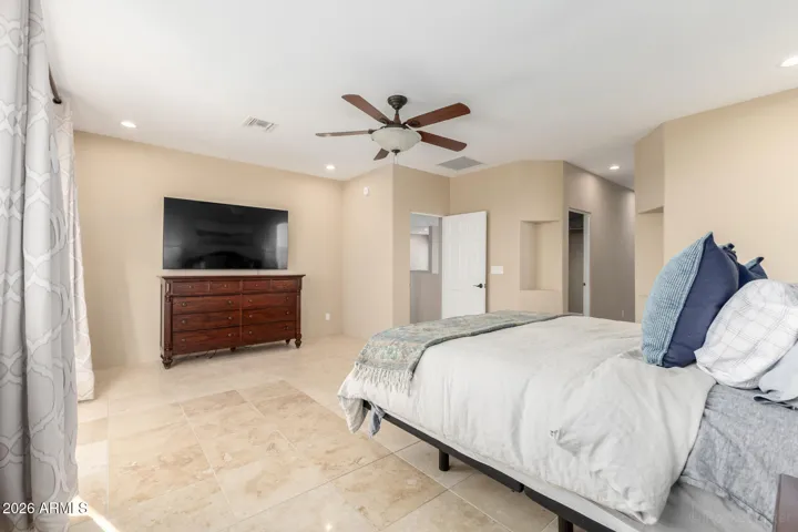 Spacious bedroom with neutral tones and a clean, relaxing ambiance.