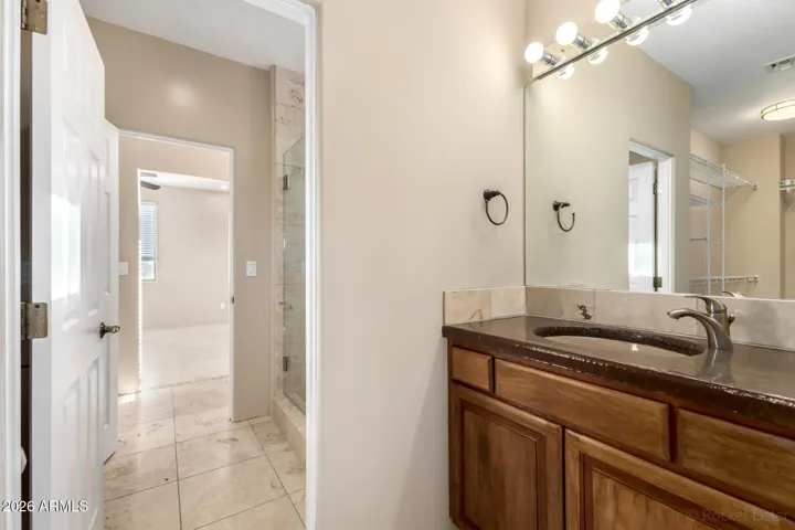 Clean and functional vanity with ample counter space and warm wood cabinetry.