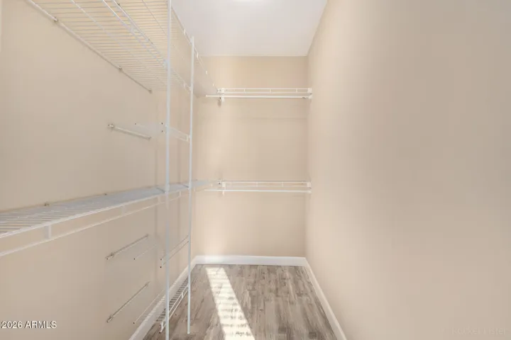 Spacious walk-in closet with built-in shelving and ample storage.
