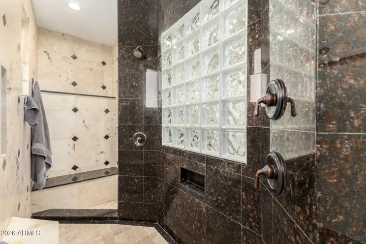Spa-inspired walk-in shower with custom tilework and glass block accents.