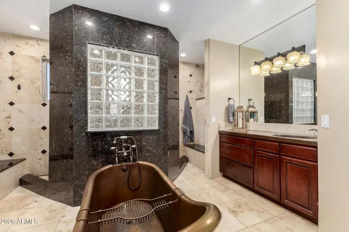 Luxurious bath featuring a freestanding COPPER soaking tub and dual vanity.
