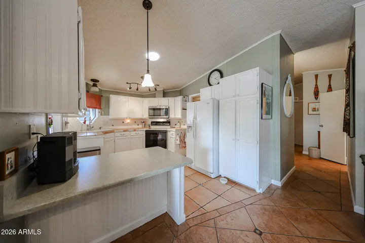 Kitchen with white cabinets and built in peninsula-counter